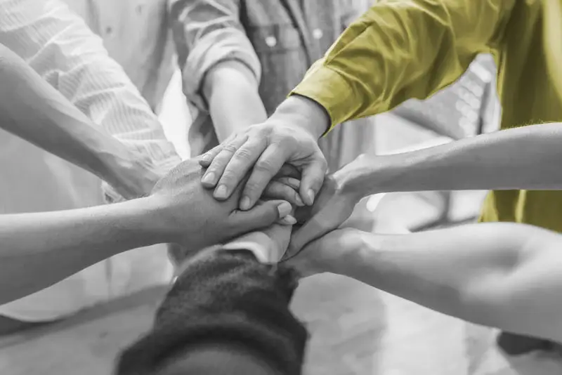 Hands coming together like in a sports cheer before playing