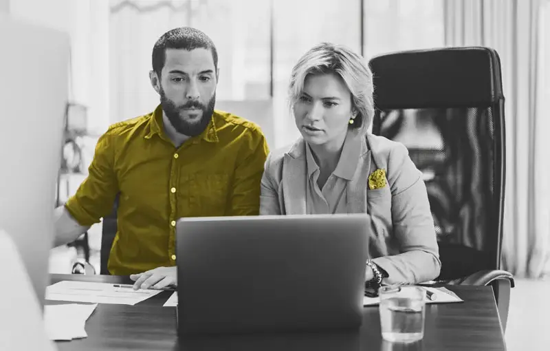 Man and woman looking at laptop in an office