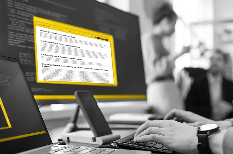 Person typing at a yellow computer monitor