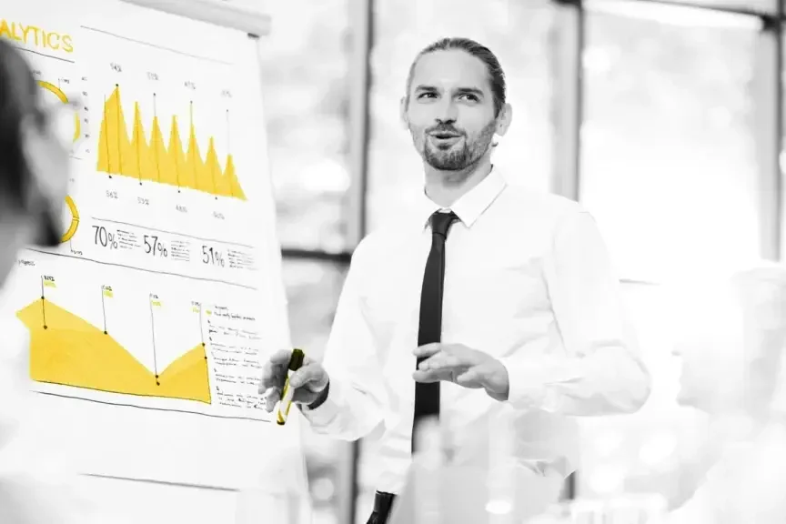 Guy presenting charts and graphs in a conference room