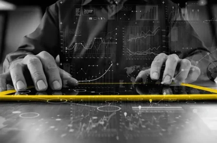 A person typing on a yellow tablet, overlaid with charts and graphs
