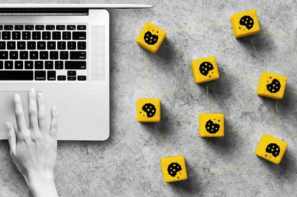 Hand on a laptop with wooden blocks next to them. Cookie icon on each block.